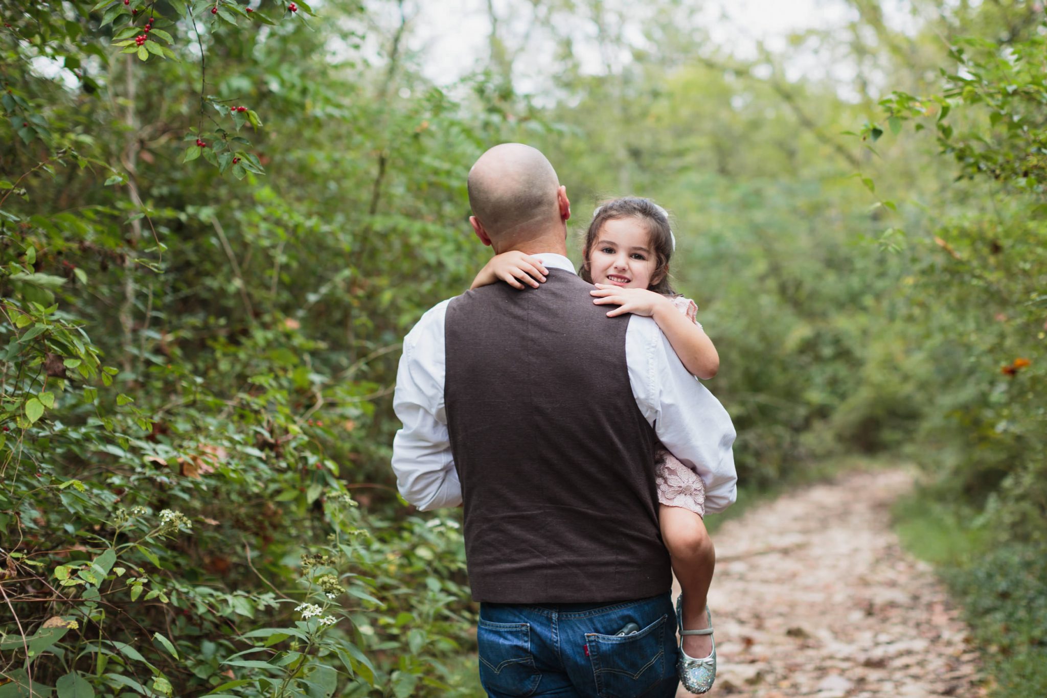 Ijams Nature Center, dad wearing vest carrying daughter on family hike