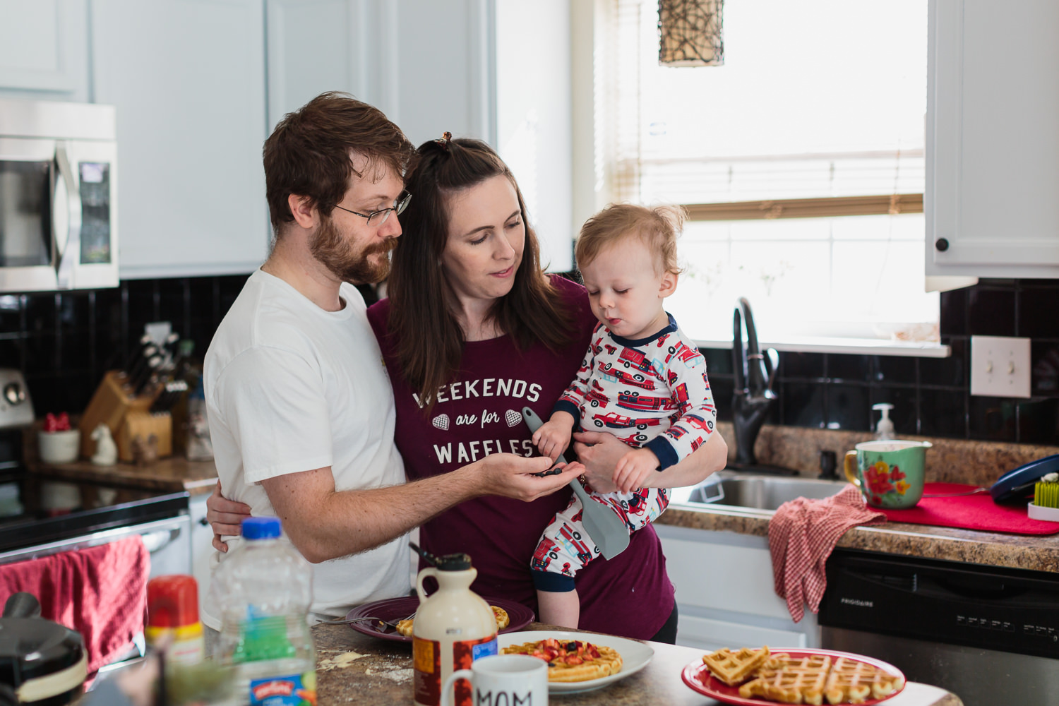 family holding baby eating waffles