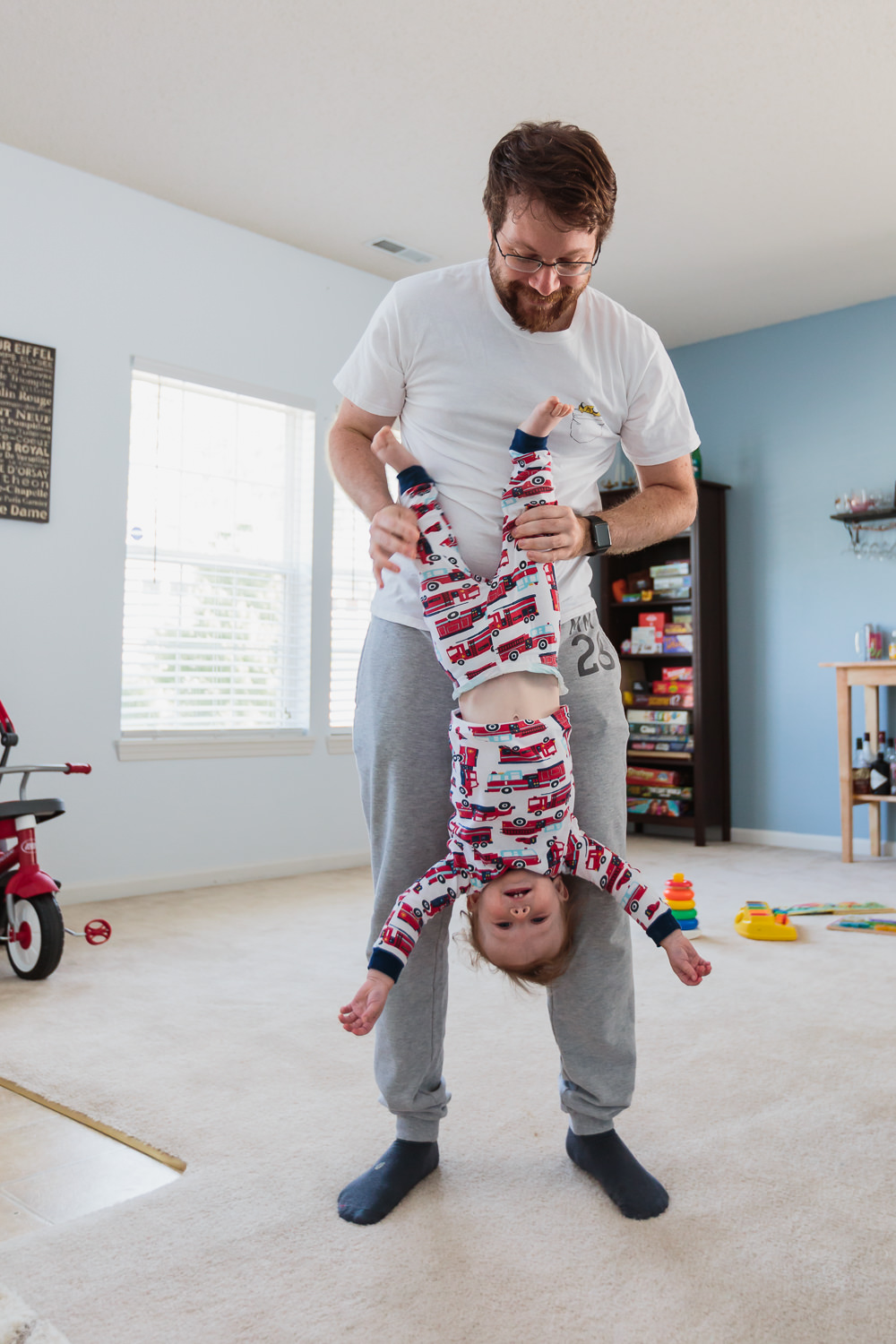 dad holding boy upside down in living room